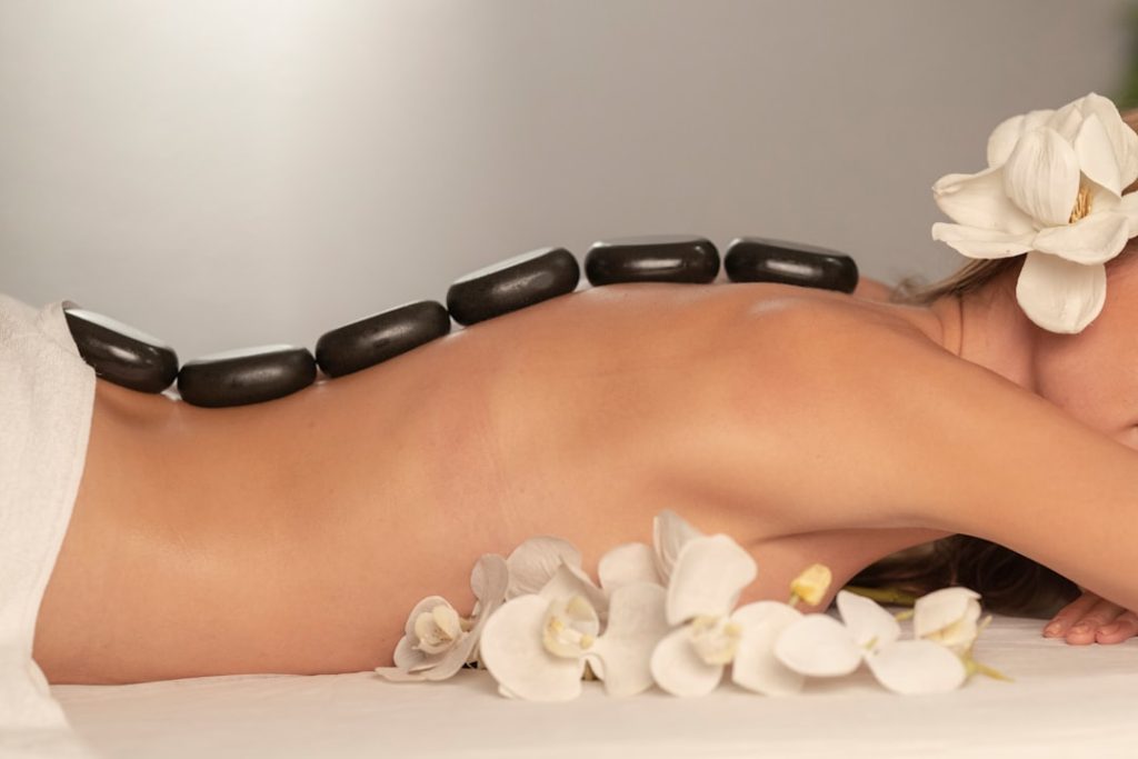Woman getting a hot stone massage at spa salon