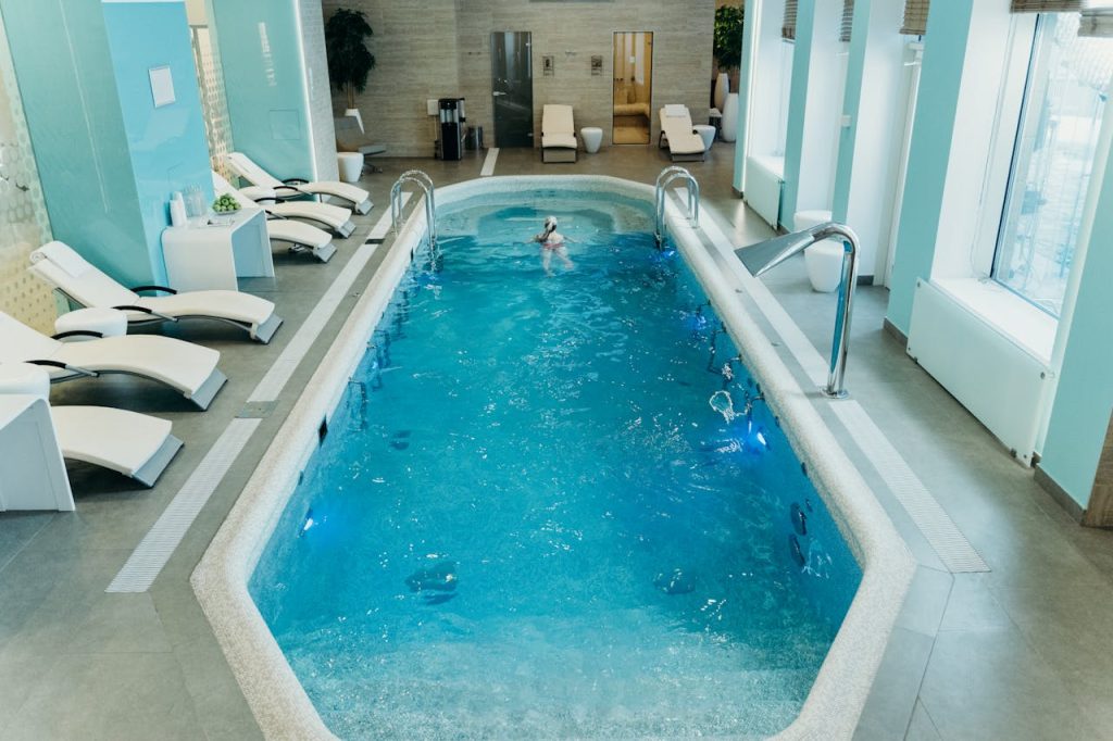 Bright indoor spa pool with lounge chairs and calm atmosphere, ideal for relaxation.